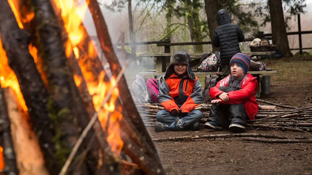 Campers gathered around a winter bonfire
