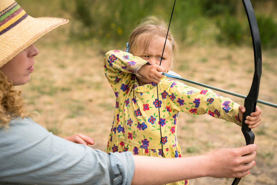 Forest skills educator teaching archery outdoors