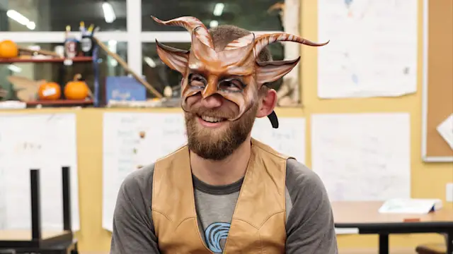 Guide in a horned mask telling stories at Track-or-Treat