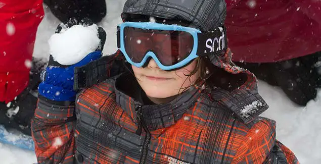 Camper playing in the snow at winter camp