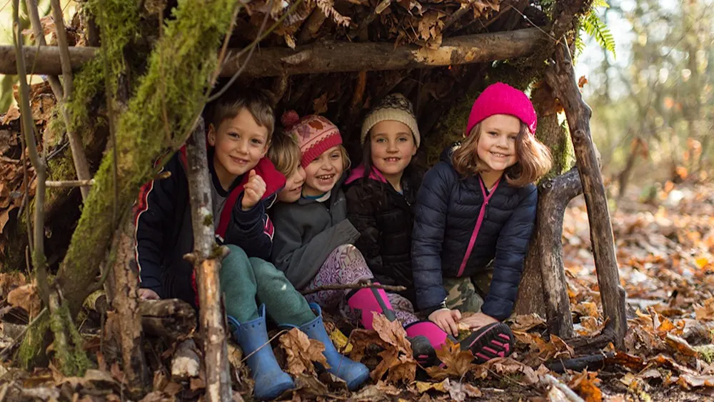 Campers exploring the winter forest at Trackers Winter Break Camp
