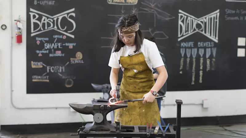 Blacksmith shaping hot iron at the Trackers forge